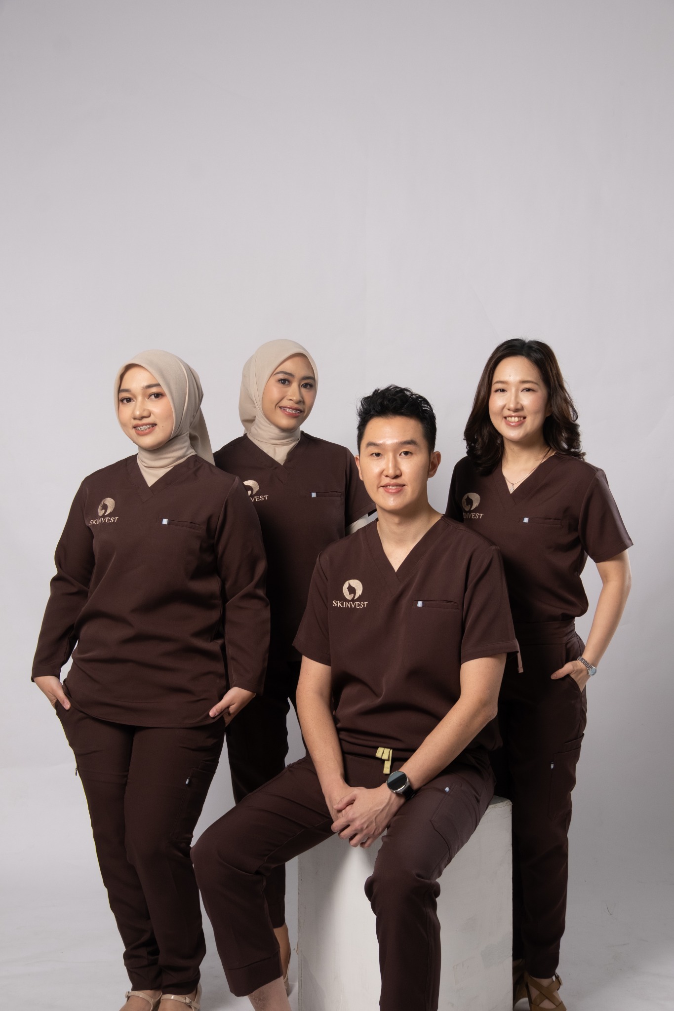 Empat dokter Skinvest mengenakan scrub cokelat dalam satu frame