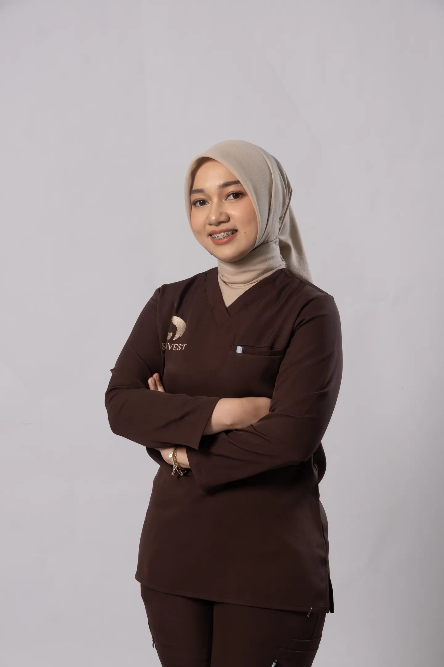Foto dr. Nafisya Dhira Bella H., Dipl. AAAM mengenakan scrub cokelat Skinvest